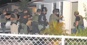 Officers prepare to enter a suspect grow house