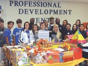 Brothers of Iota Pi Lambda Chapter of Alpha Phi Alpha Fraternity stand among student volunteers from Devon Aire K-8 Center prior to food basket distribution.