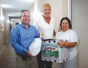 Councilmember Patrick Fiore (center) and Vice Mayor-Elect JohnDubois (left) deliver a holiday food box to Palmetto Bay resident Emma Perez at Royal Coast Apartments.