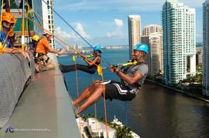 In an adrenaline-rushing demonstration of their commitment to improve the lives of Miami children and families, the first “Over The Edge” rappellers, Aubrina Mumford and Les Bradley, prepare to go 19 stories down the JW Marriot Marquis on Sept. 5, 2013.