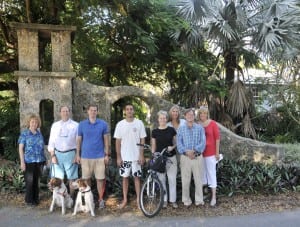 High Pines residents are planning to save, rebuild and restore the distinctive and historic native coral rock arches that define their neighborhood; the pillars are presently in various stages of disrepair. Pictured from left: J.T. Rawlins, T.K. Heatley, James Heatley, Austin Matheson, Suzanne Martinson, Elizabeth Smith, Henry Matheson and Susan Heatley are among the project's grassroots organizers. Brittany Spaniels Lucy and Slater Heatley manage "community outreach!"