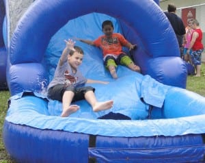 Elementary students enjoying water slide.