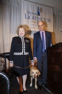 From left, Virginia Jacko, President & CEO, Miami Lighthouse for the Blind with her guide dog Kieran, and Tom Wlodkowski, Vice President of Accessibility for Comcast Cable, at the Miami Lighthouse for the Blind’s “See the Light Luncheon” at the Riviera Country Club in Coral Gables on November 12, 2015.