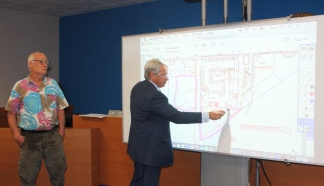 City Manager Steve Alexander points to a city map during the last COW meeting on city hall's prospects, while Vice Mayor Bob Welsh looks on.