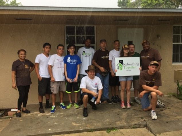 UPS volunteers present check, paint, landscape home of senior