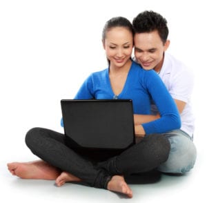 happy Couple with laptop, sitting on white floor