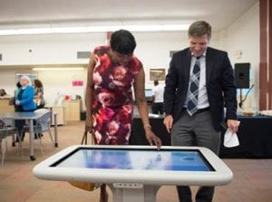 Vice Chairwoman Audrey M. Edmonson and Miami Dade Public Library Director Ray Baker check out the new SMART Table in the children's area of the refurbished Little River Library branch. (Photos by Armando Rodriguez / Miami-Dade County)