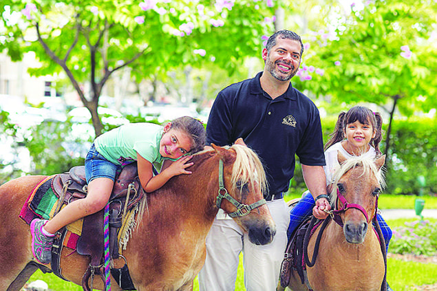 Ricardo Martinez, executive director for The Renaissance and Royale, is pictured with his children during camp at The Palace.