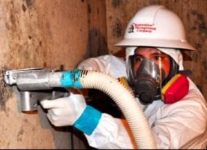 A state-certified mold remediation specialist applies dry ice to disinfect wooden beams of mold.