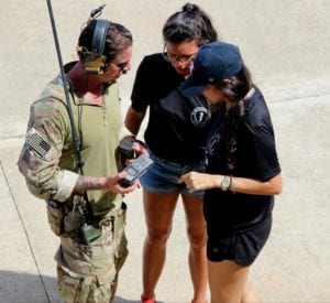 Shany Quevedo and her friend Virginia Velez get a quick lesson from “Brandon” with the U.S. Army on sat-phone usage.