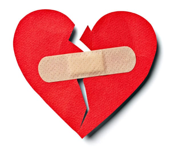 close up of aplaster and paper broken heart on white background with clipping path