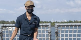 Miami Sailor handles mooring lines aboard U.S. Navy ship Miami Sailor handles mooring lines aboard U.S. Navy ship