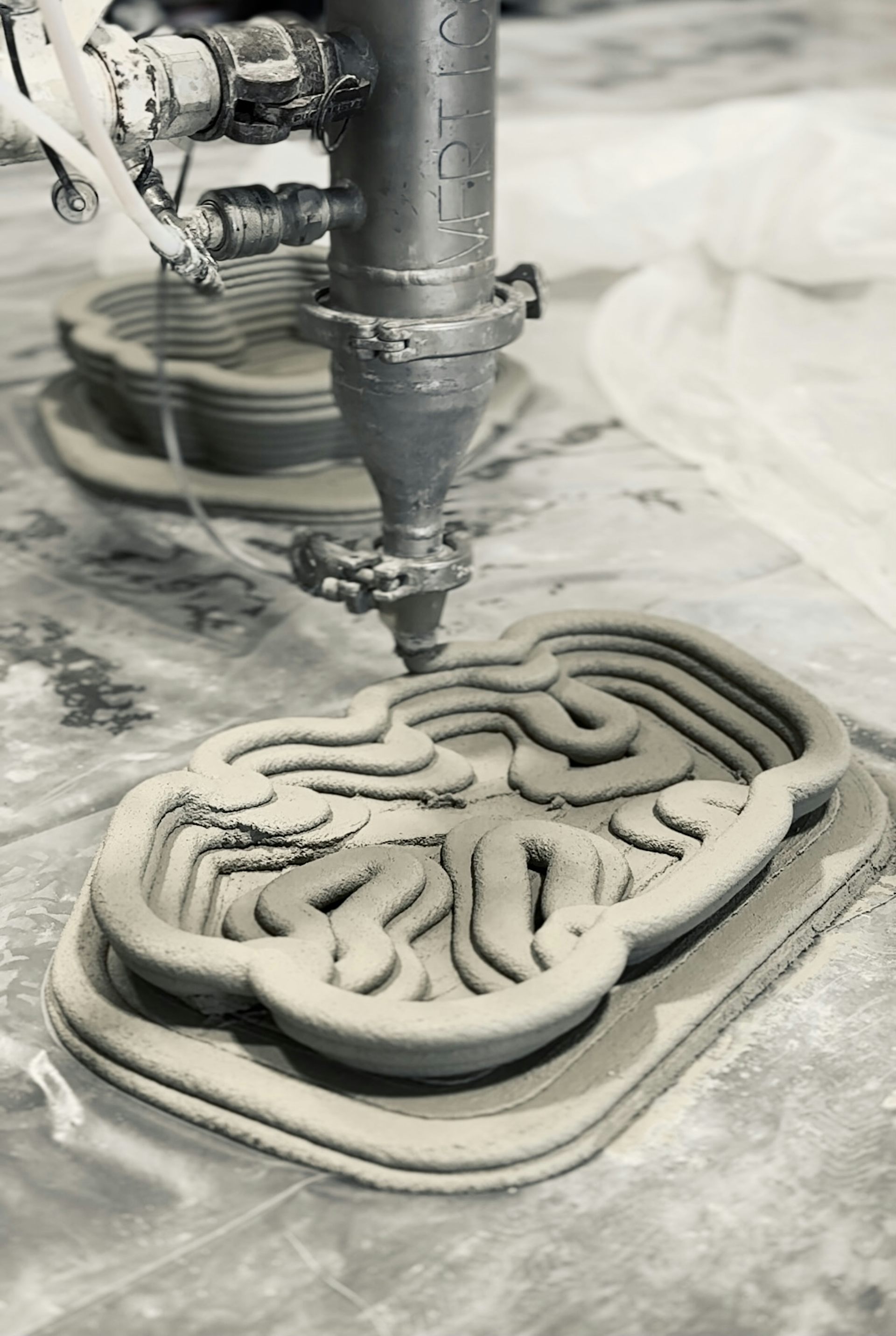 Metal machine above grey swirling multi-layered form