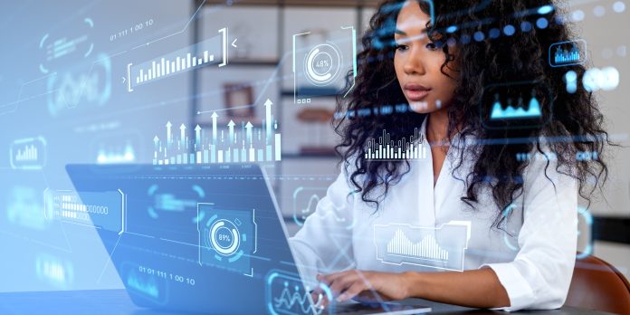 African businesswoman using computer, graph chart and hologram with statistics