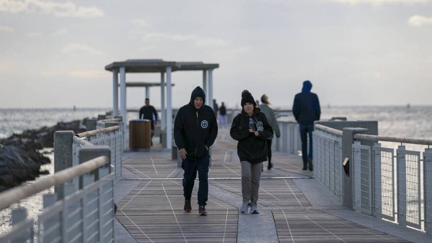 People stroll South Pointe Park in Miami Beach as temperatures dipped into the low 50s across South Florida in 2022.