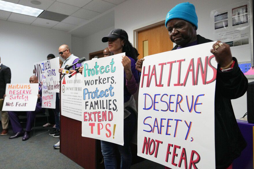 People hold signs during a rally in support of the extension of Temporary Protected Status (TPS) for Haitian immigrants before it expires on February 3, Wednesday, Jan. 28, 2026, in Fort Lauderdale, Fla. (AP Photo/Lynne Sladky)